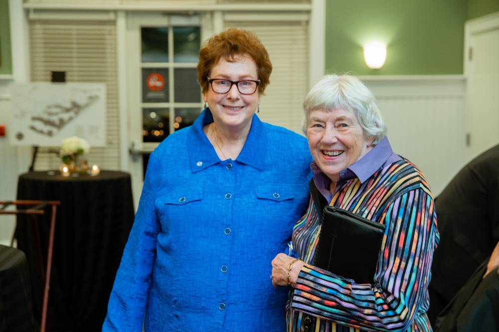 Two alumnae pose for a photo at the Reunion Dinner.
